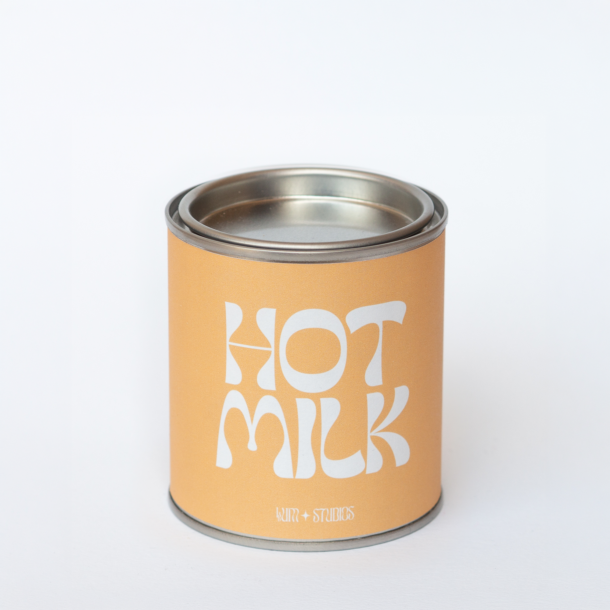 Llum Studios Hot Milk vegan scented candle in a reusable tin with warm orange sugarcane paper wraparound label, sustainably packaged and ethically made, on a white background